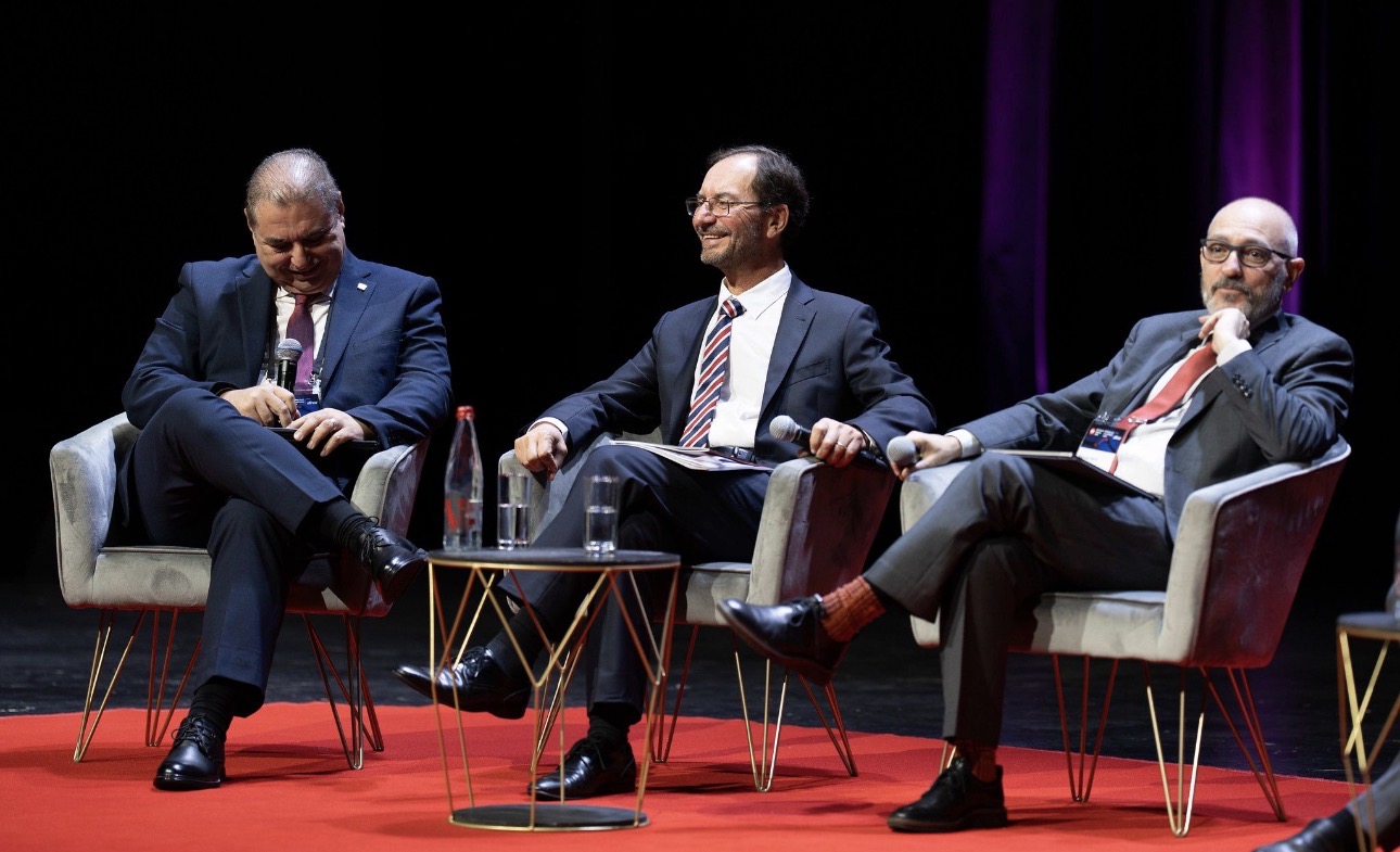 Três participantes conversam em painel de imprensa