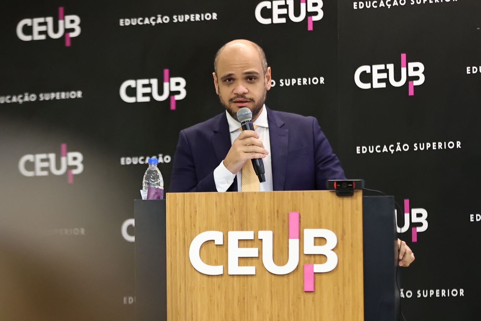 Sóstenes Marchezine profere palestra no CEUB, ao microfone e diante do púlpito da instituição.